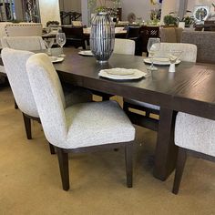 a dining room table with chairs and plates on it