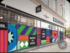 a store front with colorful posters on the windows