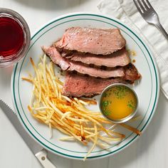 a white plate topped with meat and french fries