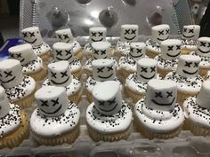 cupcakes decorated with white frosting and black stars are arranged on a tray