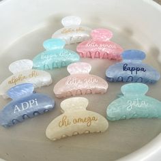 there are many different colored combs in the bowl on the table, and one is for each child's name