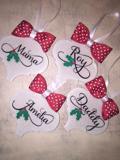 four personalized christmas ornaments with bows and holly