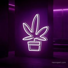 a neon sign with a potted plant in the middle on a purple wall next to a couch