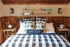 a bed in a room with wooden paneling and two paddles on the wall