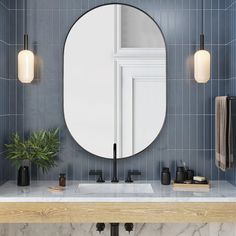 a bathroom with marble counter tops and blue tiles on the walls, along with a round mirror