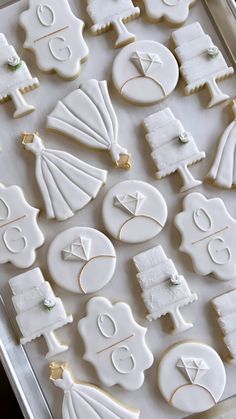 decorated cookies in the shape of bride and groom's outfits on a baking sheet