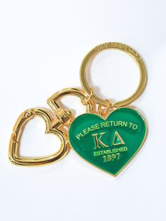 two heart shaped keychains with the words please return to ke established in gold