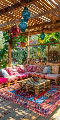 an outdoor living area with couches, rugs and lights hanging from the ceiling