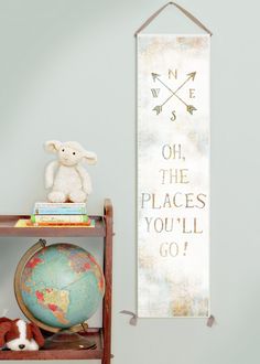 a wooden shelf with a stuffed animal on top of it next to a growth chart