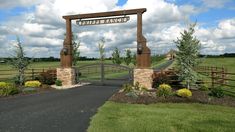 a gated entrance to an open field with trees