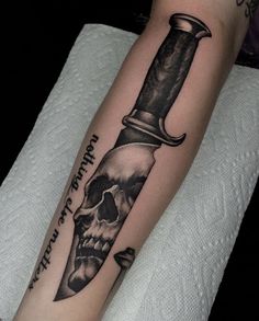 a man's arm with a knife and skull on it