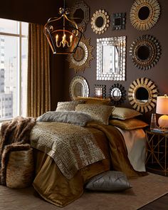 a bed room with a neatly made bed and lots of mirrors on the wall above it