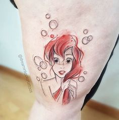 a woman's leg with a disney character tattoo on her left thigh and red hair