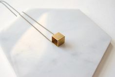 A simple vintage cube charm (12 mm wide) that I strung directly onto a nickel free aged-brass chain. It looks cool on its own, but you could also layer it because of how minimal it is. It’s fun to wear because it’s such a recognizable shape, but how often do you see it in jewelry? The charm you receive will have slight age spots, making each one unique.  It looks vintage because it is!*If you prefer a different length, just let me know during checkout!*► DETAILS:Chain length: 24 inches (61 cm)Pe Minimalist Rectangular Brass Jewelry, Minimalist Brass Square Pendant Jewelry, Minimalist Square Metal Jewelry, Minimalist Brass Necklace With Square Pendant, Cube Necklace, Chevron Necklace, Cute Box, Bezel Pendant, Geometric Necklace