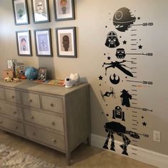 a wall with some pictures on it and a dresser in front of the wall is decorated with star wars decals