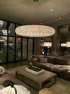 a living room filled with furniture and a large chandelier hanging from the ceiling