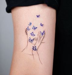 a woman's tattoo with blue butterflies flying around her