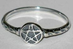 This delicate sterling silver ring features a solid pentagram at its center, accented by a spiraling rope design that works down both sides of the band. 5/8" across, size 4.