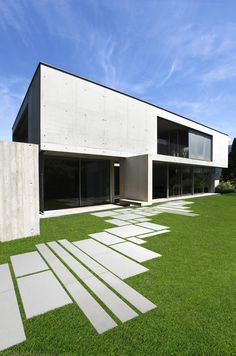 a modern house with grass in the front yard