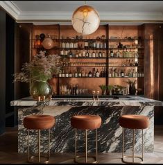 an elegant bar with marble counter tops and stools