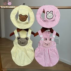 three baby bibs with animals on them hanging from a rail next to a wall