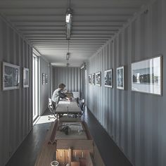 a man sitting at a table in a room with lots of pictures on the wall