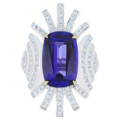 Elegant and Exquisitely detailed White Gold Ring, with a rare 10.4 Cts (approx.) Cushion Round Corner in faceted Cut Tanzanite set in the center beautifully accented with Micro pave set Diamonds, weighing approx. 2.7 CT's (approx.). total carats weight the beauty of the Ring. Beautifully Handcrafted in 18 Karat White Gold Product Details: - Primary Stone: - Tanzanite Primary Stone Shape: - Cushion Round Corner Primary Stone Cut: - Faceted Primary Stone Size: - 117X10.5MM Primary Stone Weight: -