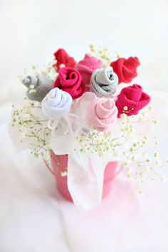 a pink vase filled with baby's breath flowers on top of a white table