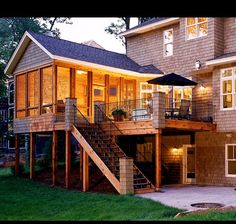 a large house with stairs leading up to the second floor and an umbrella on top of it