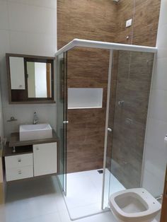 a bathroom with a toilet, sink and shower stall in the middle of the room