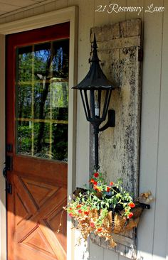 an old door with a lamp and window box on it