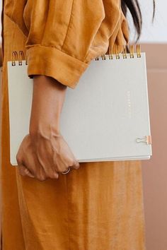 a woman holding a notebook in her hand