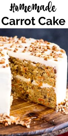 a carrot cake with white frosting and chopped nuts on top, sitting on a wooden cutting board