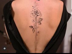 the back of a woman's neck with a rose tattoo on it