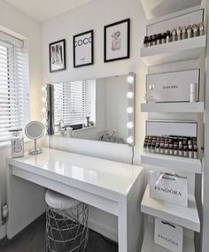 a white vanity with lots of lights on the top and shelves above it in front of a window