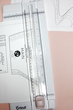 a pair of rulers sitting next to each other on top of a pink tablecloth