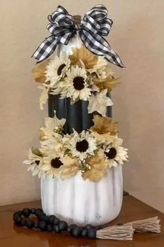 a white pumpkin decorated with sunflowers and blackberries