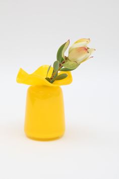 a yellow vase with a flower in it