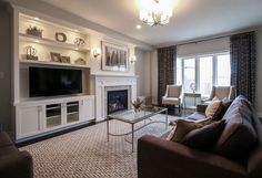 a living room filled with furniture and a flat screen tv mounted on a wall above a fire place