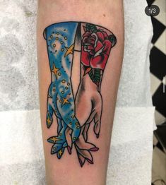 a tattoo with two hands holding each other's fingers and flowers on the arm