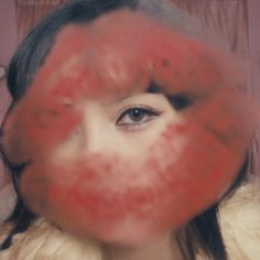 a woman's face is shown through a red circular object in front of her