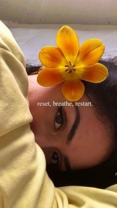 a woman laying on top of a bed with a flower in her hair and the caption reads rest breathe rest