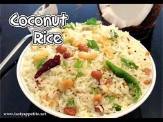 a white bowl filled with rice and beans next to a slice of coconut on top of a table