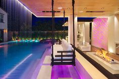 an indoor swimming pool at night with purple lighting