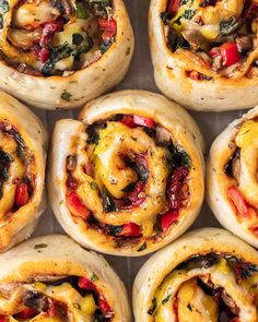 several different types of breads with cheese and vegetables on them, arranged in a circle