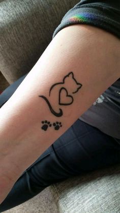 a woman with a tattoo on her arm that has a cat and heart in it