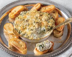 a silver plate topped with bread and dip