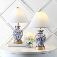 two blue and white vases sitting on top of a table