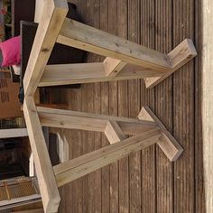 a wooden bench sitting on the side of a building