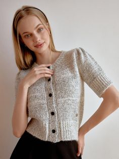 This product is a delicate half cardigan that offers both warmth and style. Featuring a classic button-up front and a cozy knit texture, this cardigan is perfect for layering over a variety of outfits. The short sleeves make it a versatile choice for different seasons and settings. The cardigan's button-up front allows for easy adjustment, making it perfect for a snug fit or a more relaxed look.Its knit texture provides a touch of elegance and comfort, suitable for day-to-day wear.The short Everyday Knit Cardigan With Button Closure, Knit Cardigan With Button Closure For Everyday, Knit Cardigan With Button Closure For Daywear, Short Sleeve Soft Knit Sweater For Fall, Winter Knit Tops For Daywear, Fitted Soft Knit Cardigan For Everyday, Classic Fitted Knit Cardigan, Short Sleeve Cardigan With Button Closure For Fall, Cozy Spring Top With Buttons